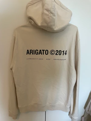 Beige Axel Arigato hoodie - hej! säljer min axel arigato hoodie då den är för stor. den är köpt i deras butik i göteborg och är ganska oversize😊nypris 2200, priset kan diskuteras