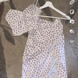 Blommigt sommar set - Blommigt set, långkjol med slits och en matchande topp från ZARA. Aldrig använt, nyskick. Toppen är i storlek S och kjolen i storlek M. Köpt för tillsammans 1000 kr.