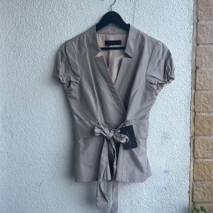 Zara topp, helt oanvänd!  - Helt oanvänd jättefin topp/tröja från Zara i gråbeige färg. Nypris 799kr. Strl L