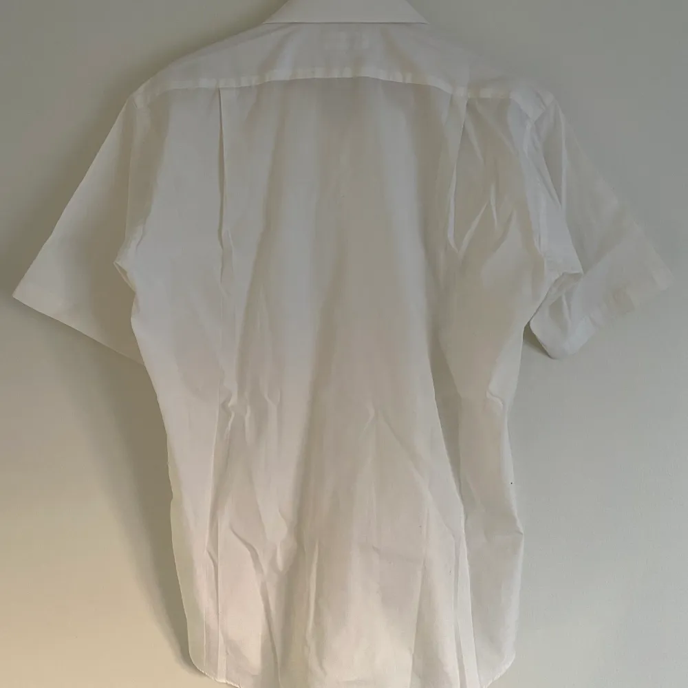 En kortärmad vit skjorta från en av Issey Miyakes diffusionslinjer, Im product. En stabil sommarskjorta i ordentligt bra material.  Storlek M, sitter lite för tight på mig.  Väldigt bra o clean som basic skjorta😎. Skjortor.