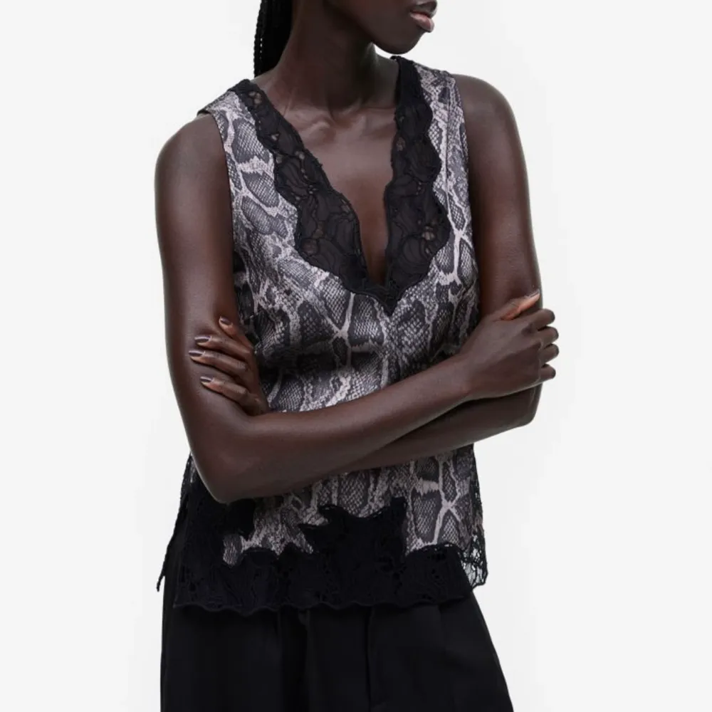Super fint glansigt linne från H&M med spetsdetaljer och knytning i ryggen!🖤🤍🤎 . Toppar.