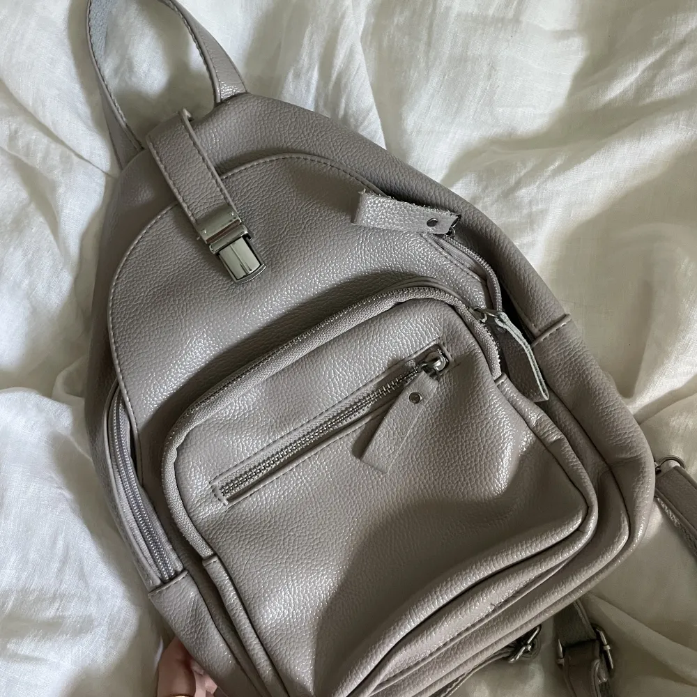 Säljer denna söta lilla grå ryggsäcken. Använd endast en gång och är som ny. Får plats med rätt mycket trots liten storlek🎒😎💕💕. Accessoarer.