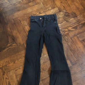 Utsvängda jeans - Svarta jeans som är utsvängda, som man ser på bilden är de lite utdragna vid grenen.