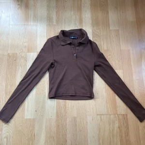 Henley - Brun henley med krage. Bra skick. Kroppad i magen. Mysig till hösten.