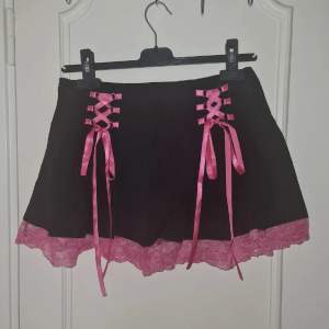 Söt lace up pleated skirt. Med rosa snören att justera storleken. Ganska tunnt material fint skick. Står storlek M men känns mer XS-S. Passar midjemått ca 60-68.  Katter finns i hemmet.