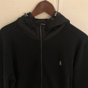 Polo Ralph Lauren zip hoodie - Säljer nu denna unika Ralph Lauren kofta som är väldigt svår att få tag på! Tröjan är bra skick! Materialet är bommul men luvan är i nylon. Hör av dig vid minsta fundering.