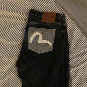 Evisu Jeans - Säljer nu mina Evisu jeans. Använda men fortfande i jätte bra skick. Äkta såklart och du får dem i påsen som dem blev skickade med. Jag säljer dem billigt för rensar garderoben,passar till både killar och tjejer 