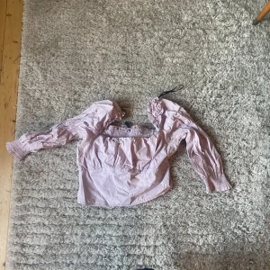 Lila tröja med puffiga armar.  - Lila tröja med puffiga armar och resår runt midjan.