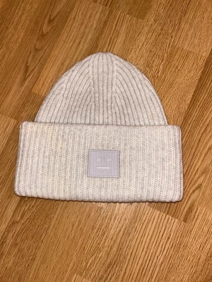 Acne mössa ljusgrå - Acne mössa i ljusgrå färg, köpt 2019 för 1600kr. Kan ej hitta att denna färgen är tillgänglig längre, men väldigt fin färg.