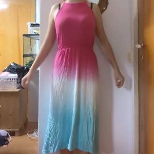 Klänning - En lång sommarklänning som är råsa, vit och blå. Har en nagellacksfläck syns på sista bilden.