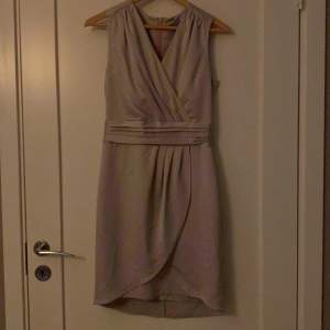 En grå/silvrig klänning i storlek 34 ifrån H&M. Den är använd men fortfarande i ett bra skick. 