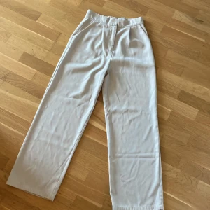 Kostymbyxor  - Tunna beiga kostymbyxor med fickor fram utan detaljer.  I gott skick 