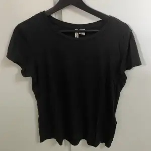 En vanlig svart bomulls T-shirt i storlek S men passar även M