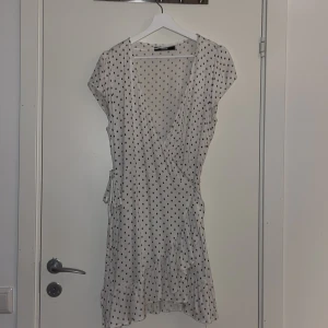 Bikbok klänning  - Säljer oanvänd omlottklänning från Bikbok. Köpte den men insåg efter att det inte riktigt var min stil och hann tyvärr klippa bort lappen