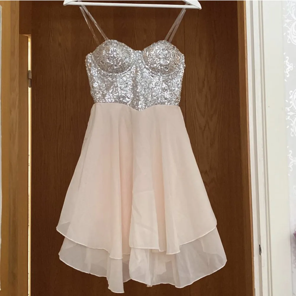 Glittrig silverrosa klänning med paljetter💖Klänningen har genomskinliga band som man kan ta av och på. Väldigt bra skick. Står storlek 10 vilket verkar motsvara storlek 38.. Klänningar.