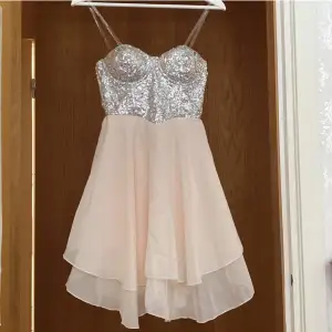 Glittrig silverrosa klänning med paljetter💖Klänningen har genomskinliga band som man kan ta av och på. Väldigt bra skick. Står storlek 10 vilket verkar motsvara storlek 38.