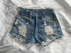 Levi’s shorts - Blåa Levi’s shorts med slitningar. Knappt använda, passar som en Xs