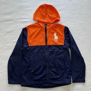 Ralph Lauren jacka - En oanvänd, tunn vindjacka från Ralph Lauren i ovanliga färger. I barnstorleken: L (14-16Y), motsvarar i detta fall kanske XXS.