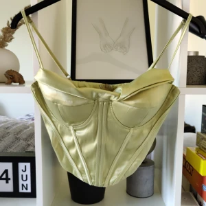 Korsett-topp - Svinsnygg grön korsett/topp. Stängs med dragkedja i ryggen och har justerbara axelband. 