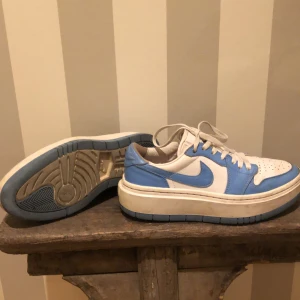 Nike Air Jordan 1 Elevate Low, blåa och vita - Sparsamt Nike Air Jordan 1 Elevate Low. Använda lite under en sommar, men de var lite för små. Har inte rengjort dem så mn kan putsa upp dem för att få sulan vit. Strl 38. Nypris 1599 kr (kartongen finns ej kvar
