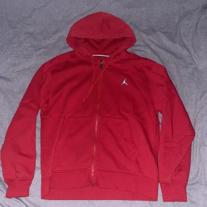 Jordan zip hoodie - Röd Storlek M - En enkel Jordan Air zip hoodie i röd färg. Endast använd två/tre gånger då den inte riktigt passade och i nyskick. Orginalpris 899kr men släpper den här för 450kr. Vid fler frågor skriv gärna. 