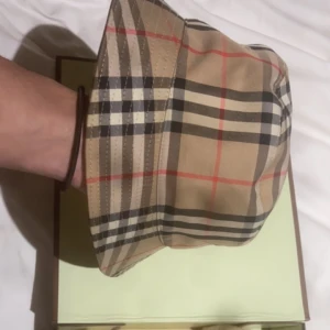 Burberry hatt - Säljer min burberry hatt den är använd ett fåtal gånger. Lådan är lite skadad men inga större fel på lådan. 