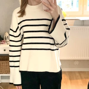 Randig stickad tröja  - Superfin vit stickad tröja med svarta ränder och slits i sidorna. Köptes på Gina tricot för ca 10 månader sen men har inte kommit till användning. Den är i 100% bomull så den blir inte nopprig som andra stickade tröjor kan bli. Nypris: 400kr