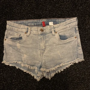Korta blå shorts - Blå korta shorts som är fake-slitna. 