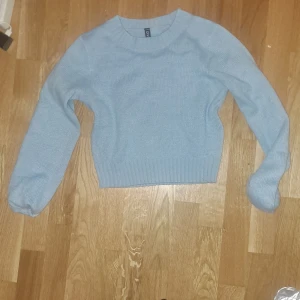Lånärmad vintertröja - Detta är en cropped ljusblå tjocktröja från HM/divided. Den är bra nu inför vintern och passar dig som har storlek xs. 