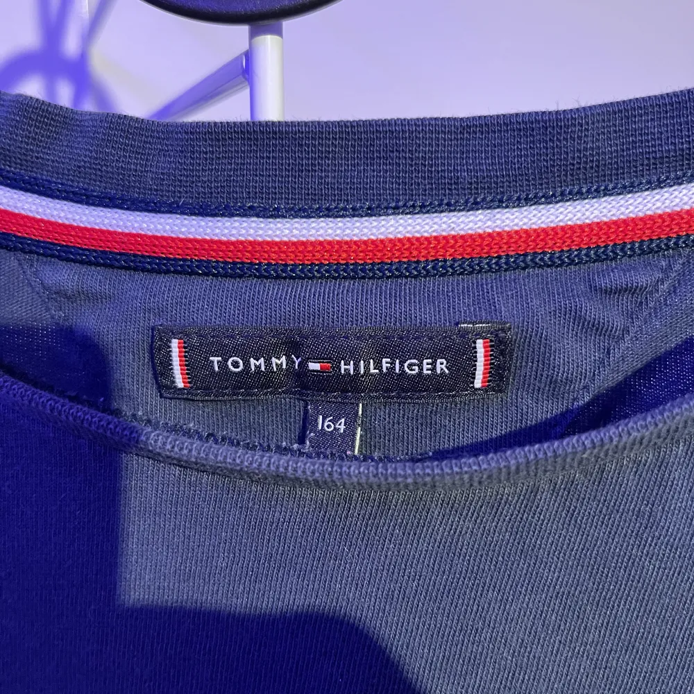 Säljer min Tommy hilfiger T-shirt mörkblå med text längst ner på framsidan och baksidan storlek 164. T-shirts.