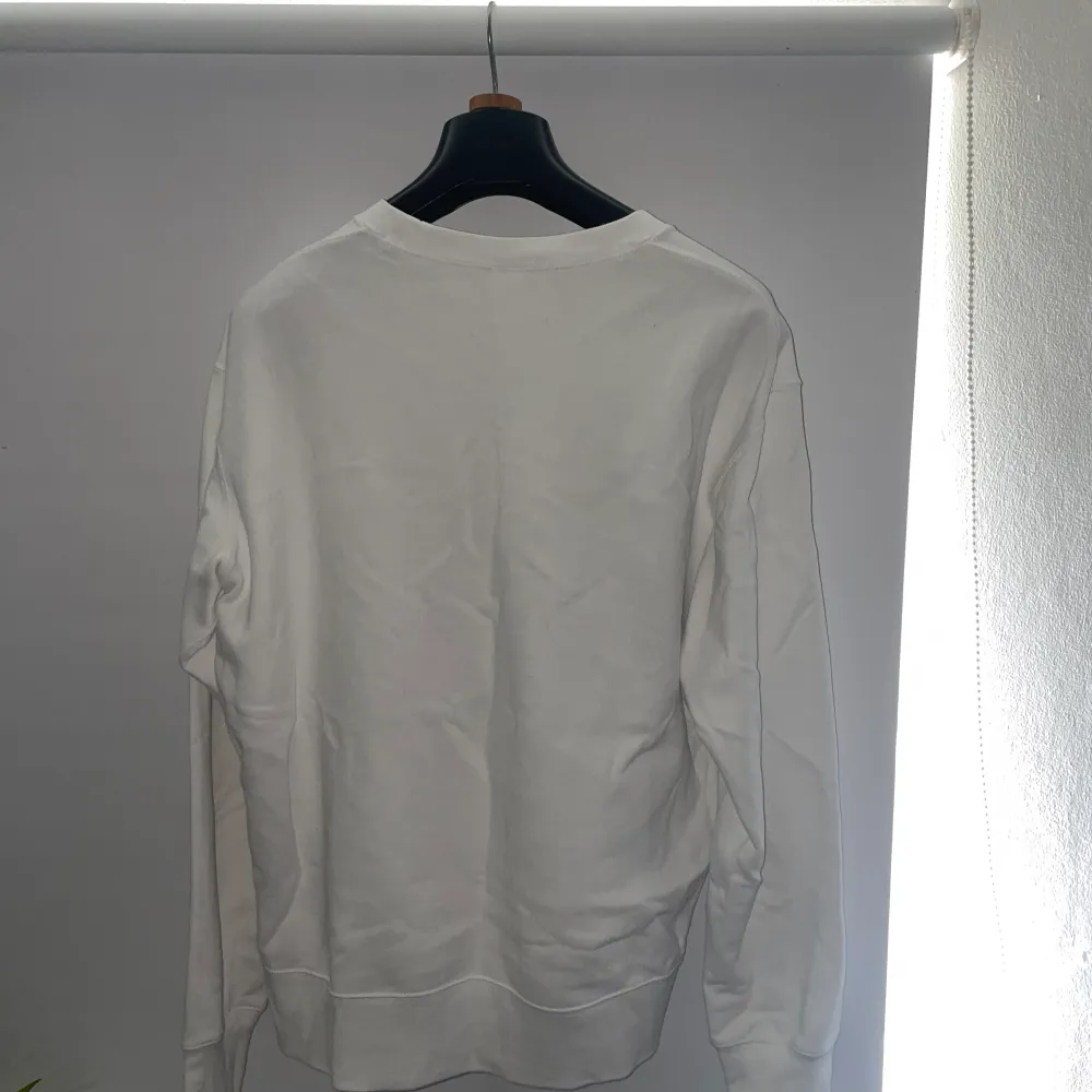 En vit design sweatshirt från Uniqlo. Designad av Keith Haring. Tröjor & Koftor.