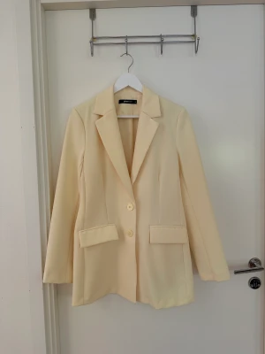 Ljusgult kostymset - Så fint kostymset i en pastellgul färg från Gina Tricot. Har endast använt det en gång på ett bröllop och är i princip som nytt. Storlek 36 på både kavaj och kostymbyxorna. Priset gäller för båda delarna tillsammans.