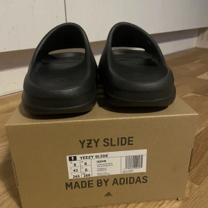 Yeezy slide onyx - Storlek 42 köpta via confirmed app, aldrig använda. kvitto box tags medföljer. Gå upp minst 1 storlek
