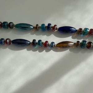 Långt halsband med stenar i olika färger