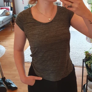 Grå t-shirt - Tunn grå t-shirt med dekorativ ficka på bröstet.