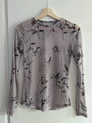 Meshtopp - Meshtopp i kall ljusrosa färg med blommotiv. Använd 1 gång, köpt secondhand. Gissar på storlek 36.