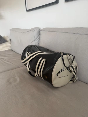  Fred Perry väska - Säljer en svart och vit väska från Fred Perry . Perfekt för gymmet eller som weekendbag. Tillverkad i slitstarkt konstläder. Skriv vid minsta fundering 