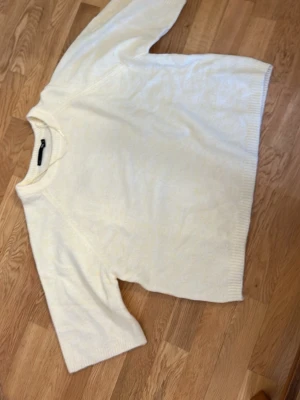 Gul  stickad tröja från 157 - Klassisk gul stickad tröja från 157 med rund halsringning och ribbade muddar. Tröjan har en avslappnad passform och är tillverkad i mjukt material, perfekt för lager på lager under kyliga dagar.