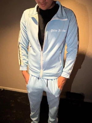 Palm angels tracksiut - Skön Palm angels tracksuit i ljus blå färg med en unik design perfekt för sommaren!      Fraktar nästa dag du köper!!