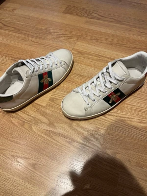 Vita sneakers med broderad bi - Snygga vita sneakers samt väl använda vilket därför priset är lågt. Kom gärna med frågor och funderingar om skorna! Priset kan diskuteras vid snabb affär.