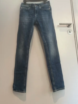 Blå Dondup slim fit jeans - Snygga blå slim fit jeans med klassisk femficksdesign och kontrastsömmar från Dondup Jeansen har en något tvättad look och är i väldigt bra skick. Längden är 30 
