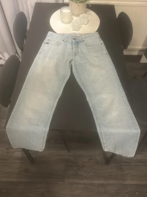 Ljusblå tiger of sweden jeans - Säljer ett par ljusblå tiger of sweden jeans med rak passform och klassisk femficksdesign. Jeansen har hög midja och är tillverkade i ett kraftigare denimtyg. Perfekta för en avslappnad och trendig look.