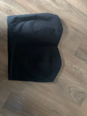 Svart bandeau tubtopp Sisters Point - Snygg svart bandeau tubtopp från Sisters Point. Enkel och stilren design utan axelband, perfekt att matcha med höga jeans eller kjol. Tillverkad i mjukt material som sitter bekvämt mot kroppen.