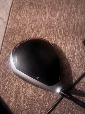 TaylorMade M6 golfklubba driver - Säljer ett klubbhuvud till en TaylorMade M6 driver. Svart och silver med röda detaljer och modern design i kolfiber och metall. Perfekt för dig som vill uppgradera din golfutrustning med en stilren och kraftfull driver. 10,5