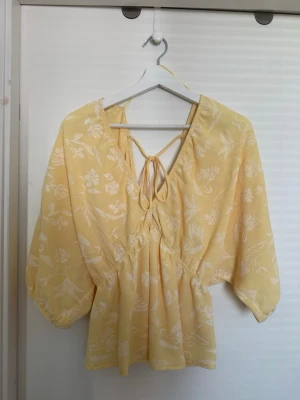 Gul trekvartsärmad topp - Gul trekvartsärmad topp med vitt mönster och snöre i ryggen från Zara i storlek S💛✨