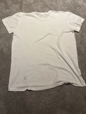 Vit polo Ralph Lauren t-shirt - Vit t-shirt i klassisk modell med rund hals och korta ärmar. Liten broderad logga i mörkblått nertill på framsidan. Perfekt basplagg i mjukt bomullsmaterial.