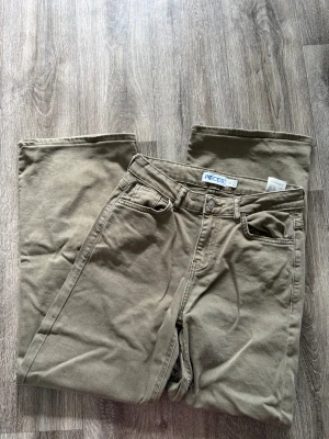 Gröna raka jeans från PIECES - Snygga gröna jeans från PIECES med rak passform och klassisk femficksdesign. Jeansen har hög midja och är tillverkade i ett mjukt bomullsmaterial med lite stretch för extra komfort. Perfekta till en avslappnad stil. Storlek W25 L30, nypris 549kr