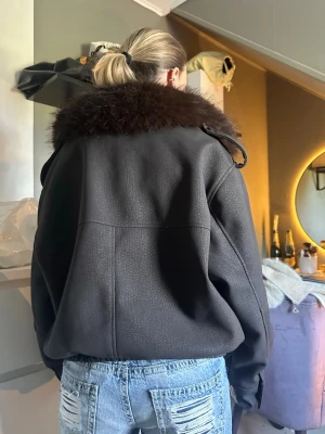 Svart skinnjacka med pälskrage - Snygg svart skinnjacka med bred, mörkbrun pälskrage, storlek m, med stora fickor. Använd fåtal gånger❤️