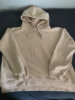 Beige hoodie  - Säljer en beige hoodie från 157 i storlek M. Hoodien har en klassisk huva med dragsko och ribbade muddar vid ärmslut och nederkant. Mjuk insida för extra komfort och enkel, stilren design utan tryck.