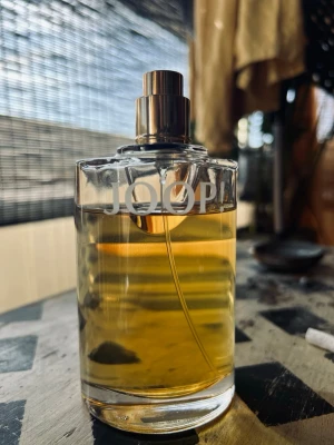 Joop! Femme edp, 100ml - Snygg parfym från Joop! i en rund, transparent glasflaska med metallisk spraypump. Flaskan har en stilren design och innehållet är bärnstensfärgat. Perfekt för dig som gillar klassiska dofter och vill ha en elegant flaska på hyllan.